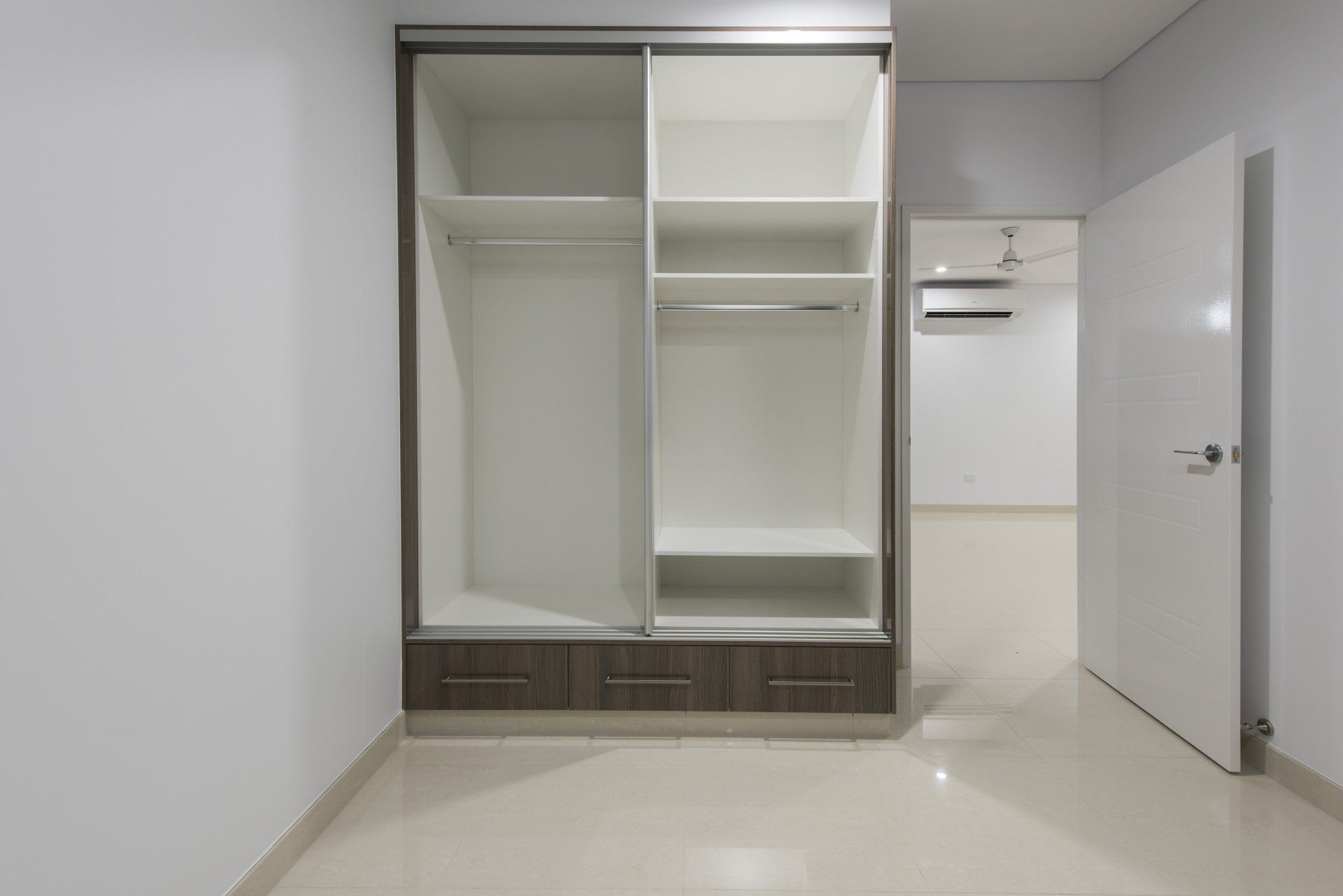 An empty room with a closet and a door