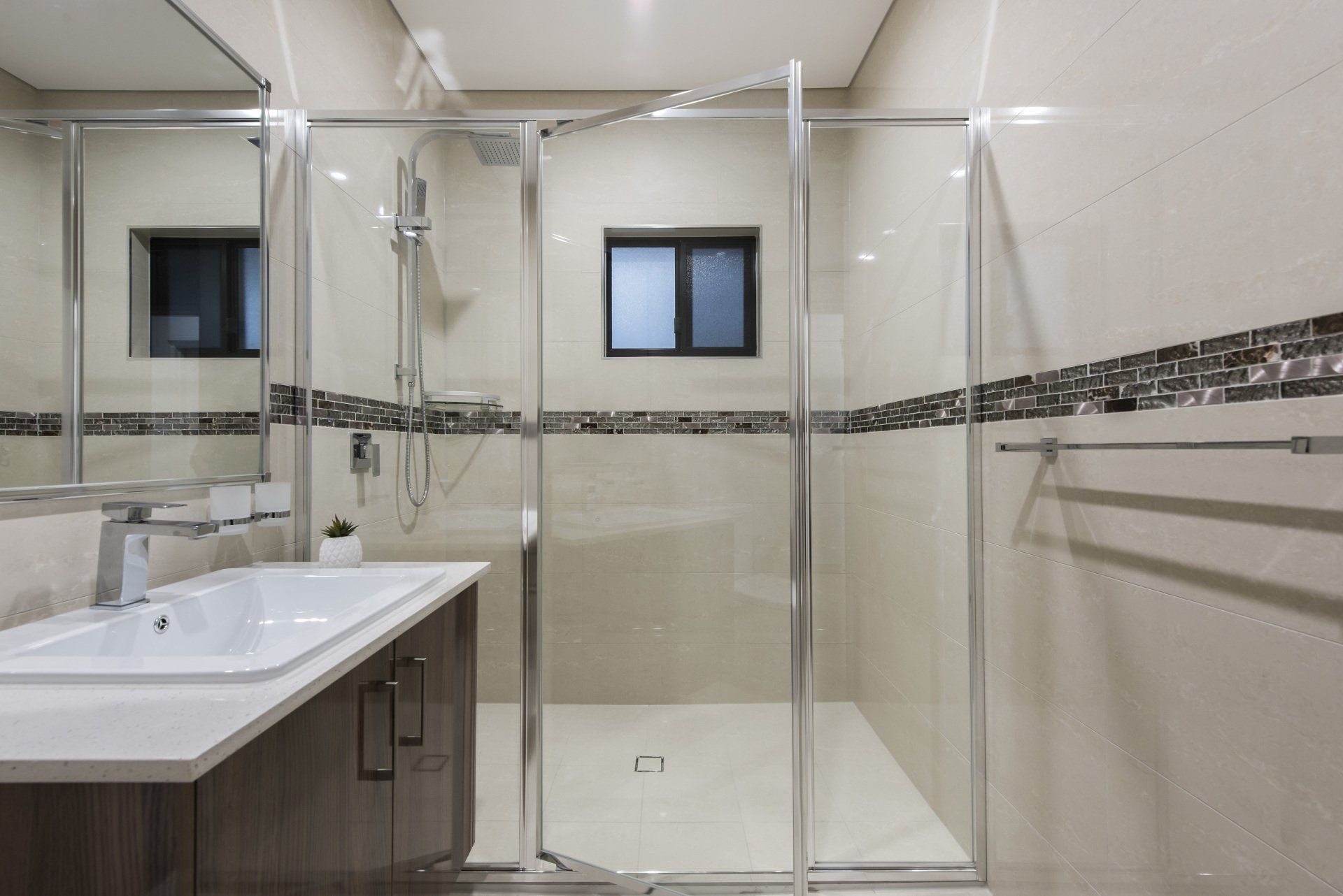 A bathroom with a sink and a walk in shower.