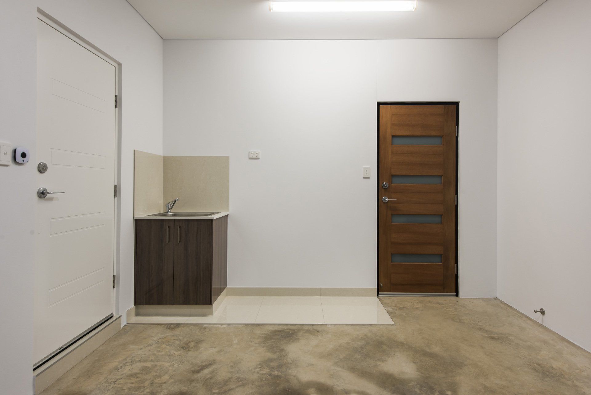 An empty room with a sink and a door