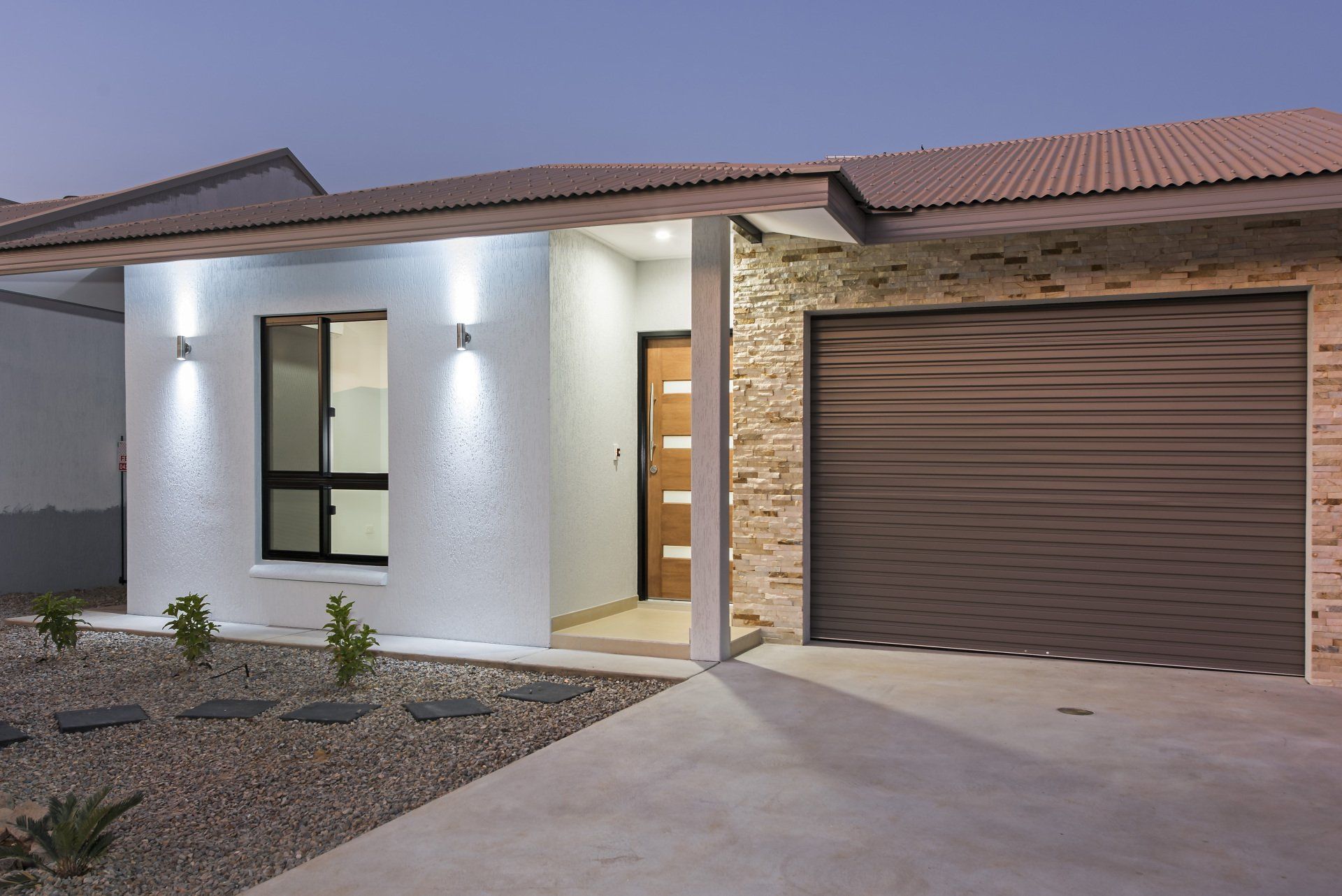 A white house with a brown garage door