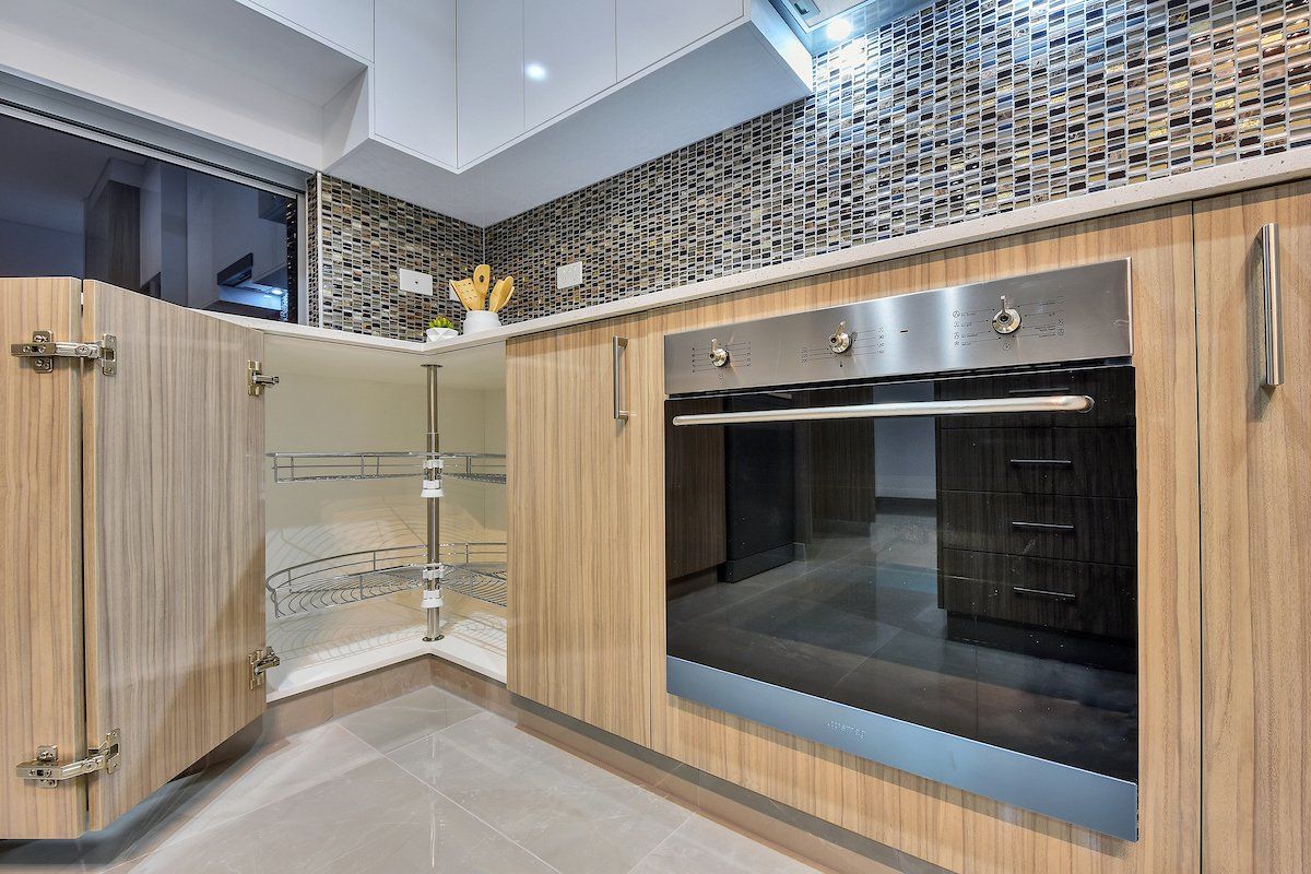 A kitchen with wooden cabinets and a stainless steel oven.