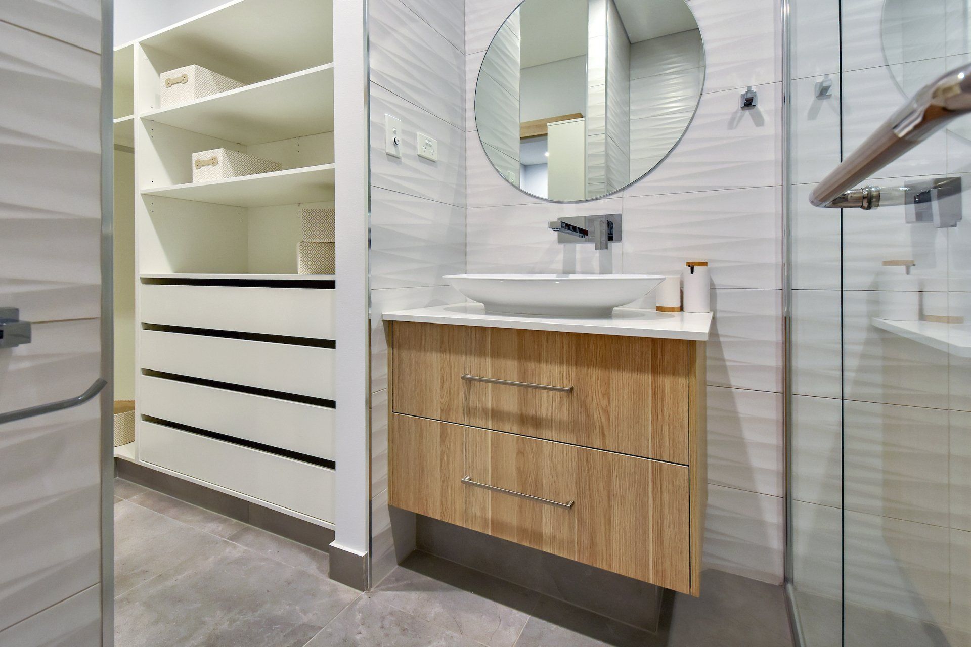 A bathroom with a sink , mirror and walk in closet.