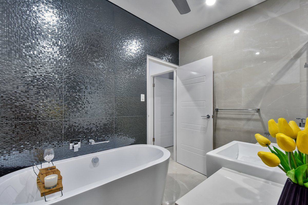 A bathroom with a bathtub , sink and a ceiling fan.
