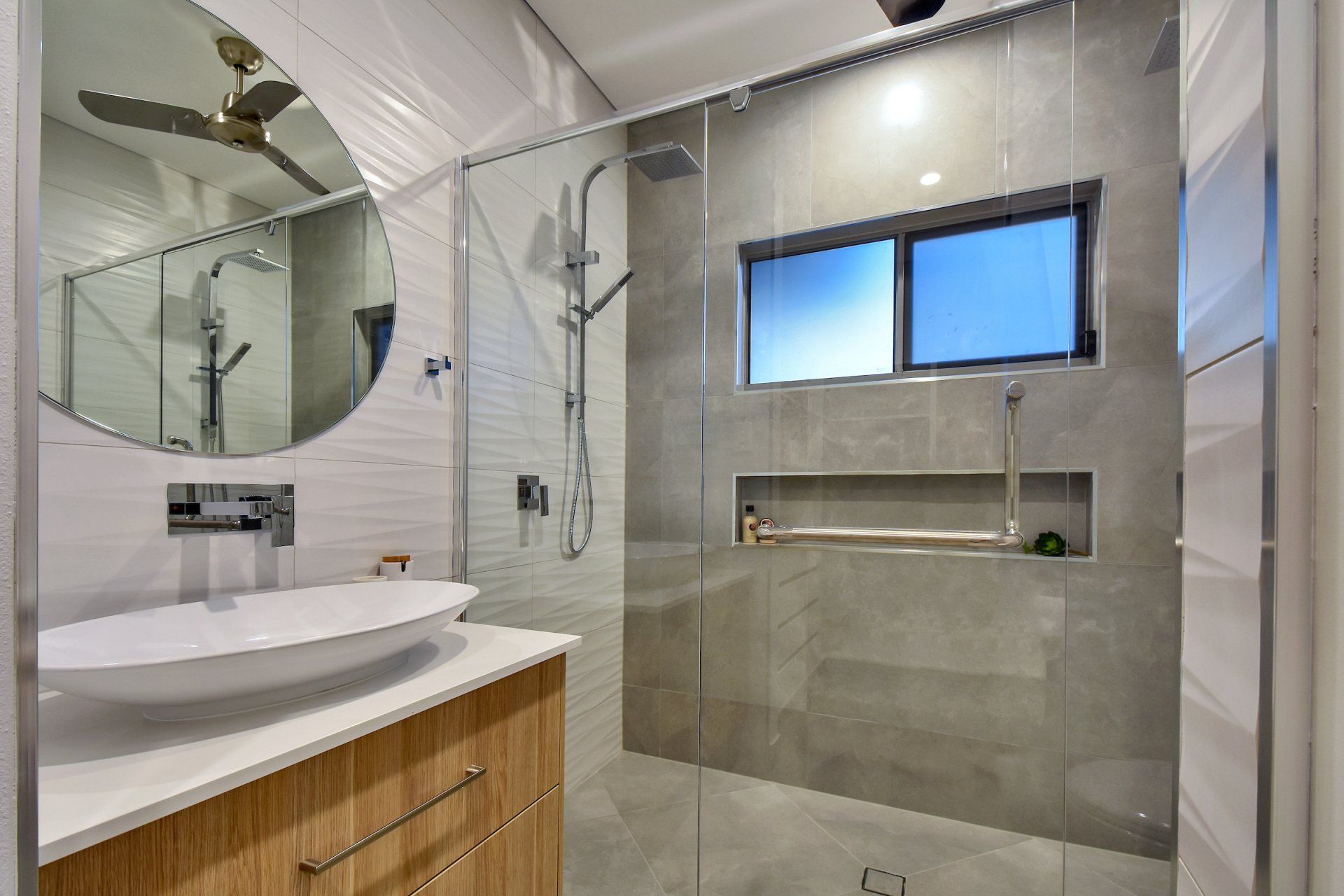 A bathroom with a sink and a walk in shower.