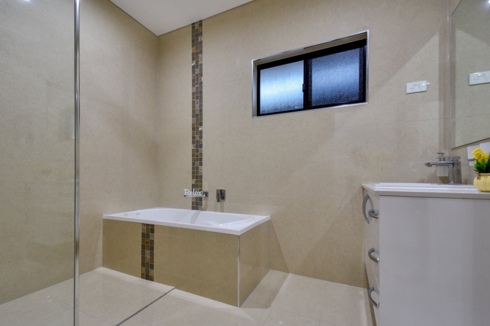 A bathroom with a bathtub , sink , mirror and walk in shower.