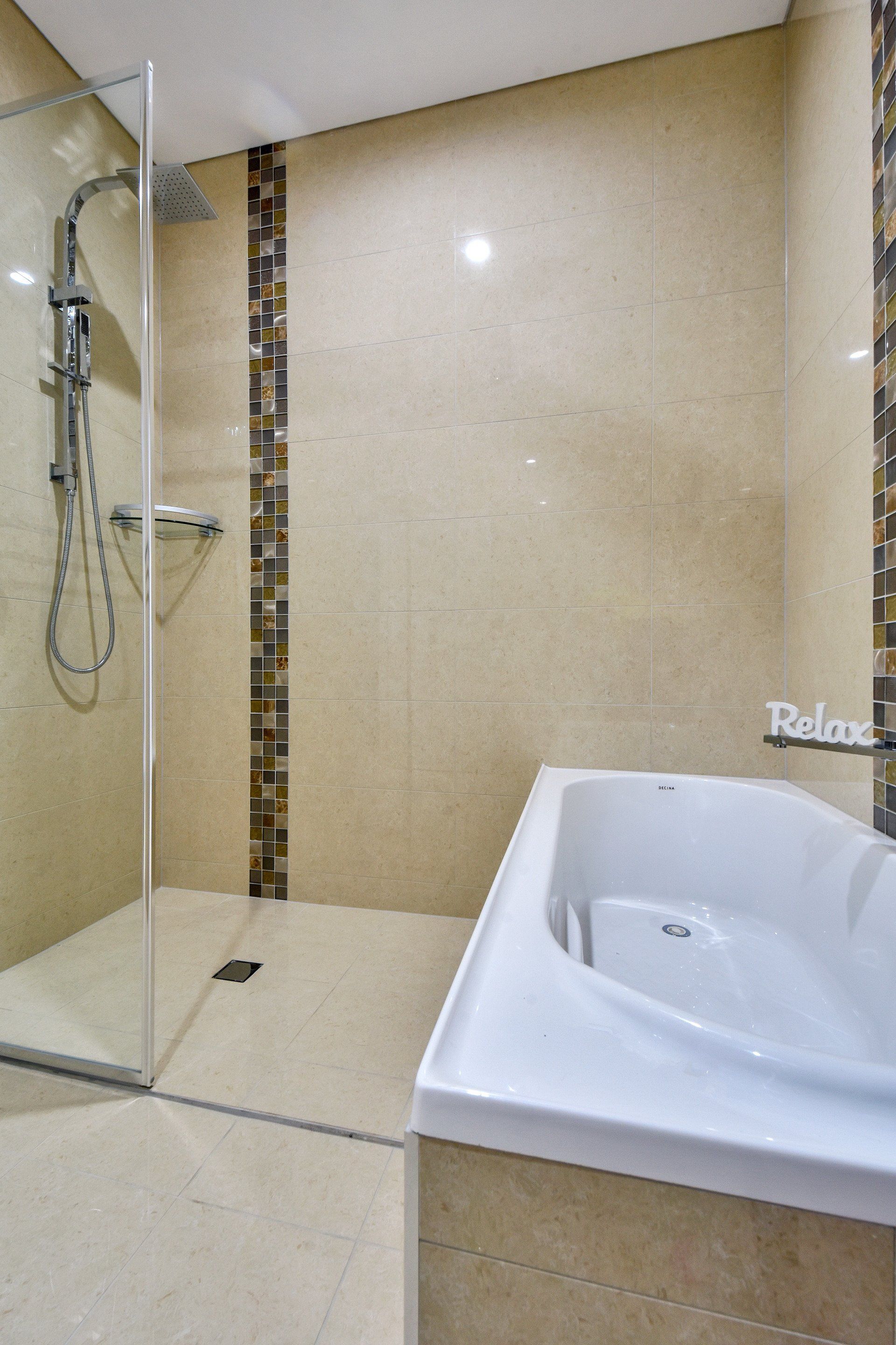A bathroom with a bathtub and a walk in shower.