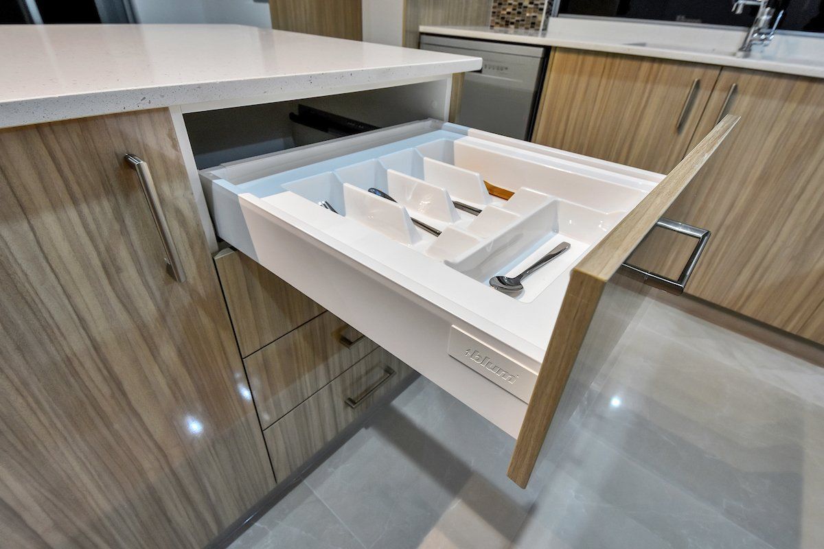 A kitchen drawer with a spoon and fork in it.