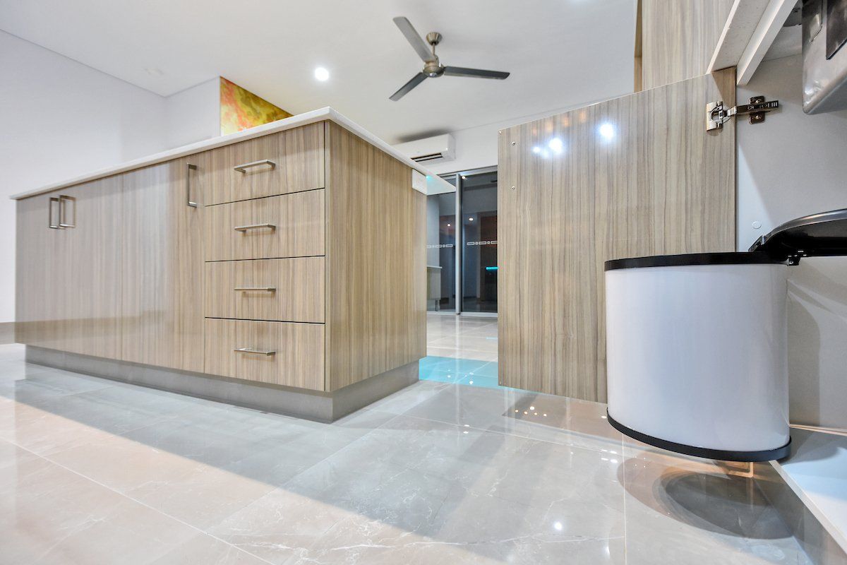 A kitchen with wooden cabinets and a ceiling fan.