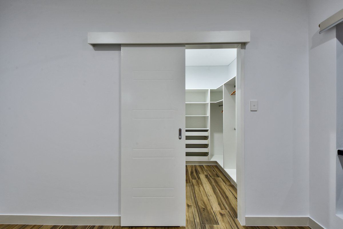 An empty room with a sliding door leading to a walk in closet.