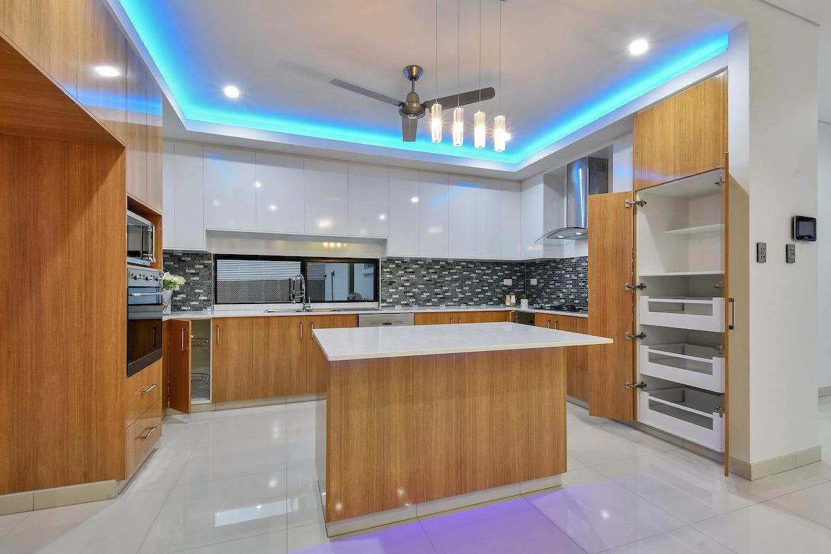 A kitchen with a large island in the middle and a ceiling fan.