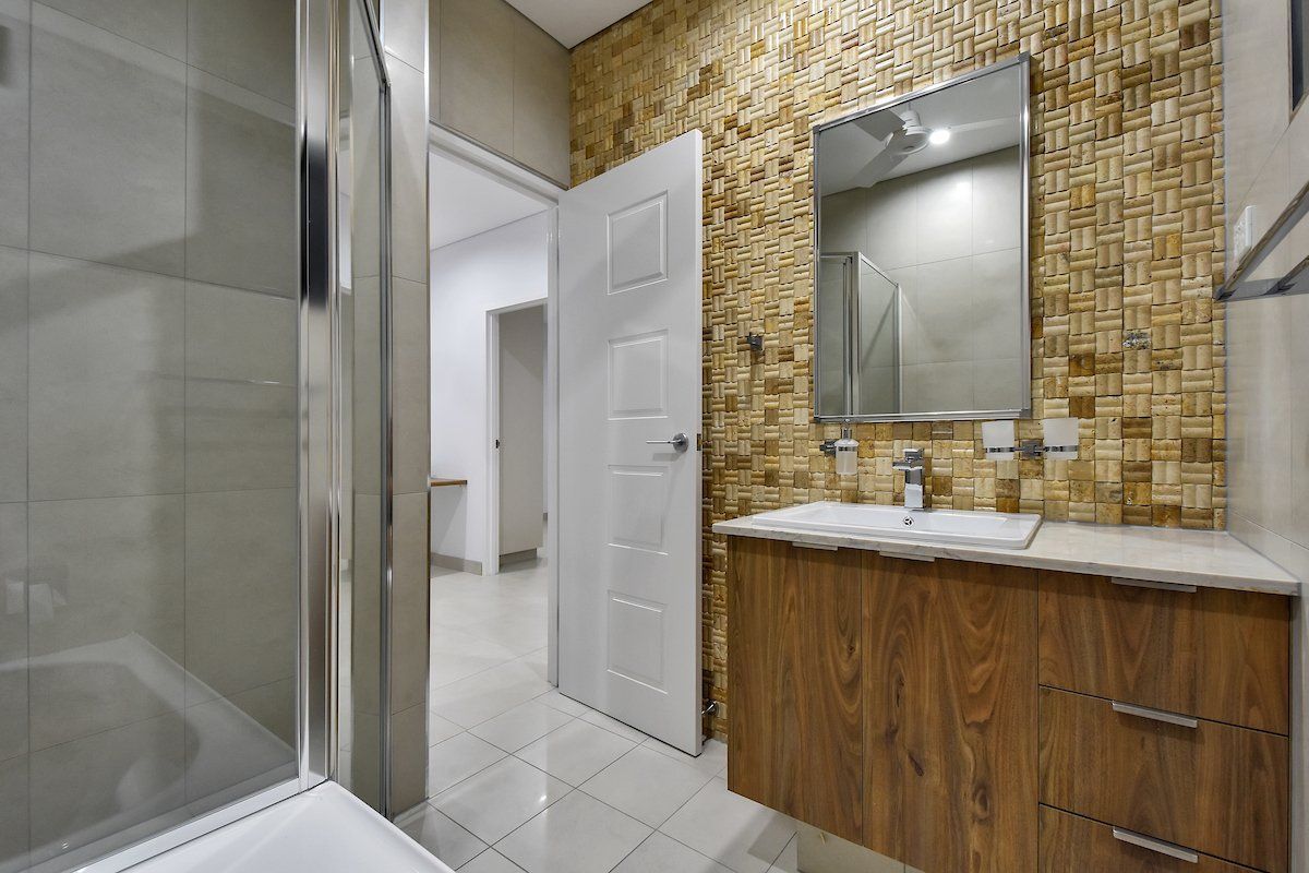 A bathroom with a sink , mirror and toilet.