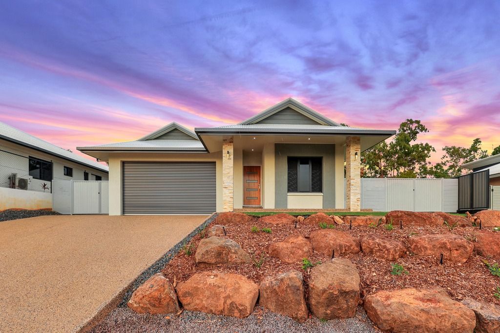 An empty living room with a ceiling fan and a stone wall.