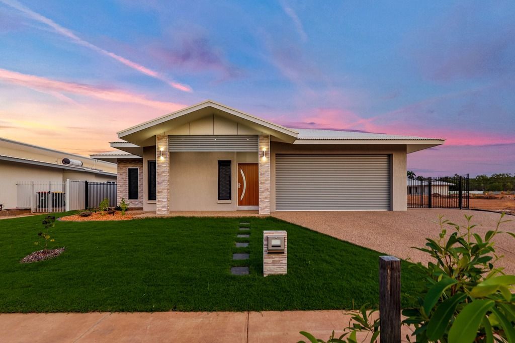 An empty living room with a ceiling fan and a stone wall.