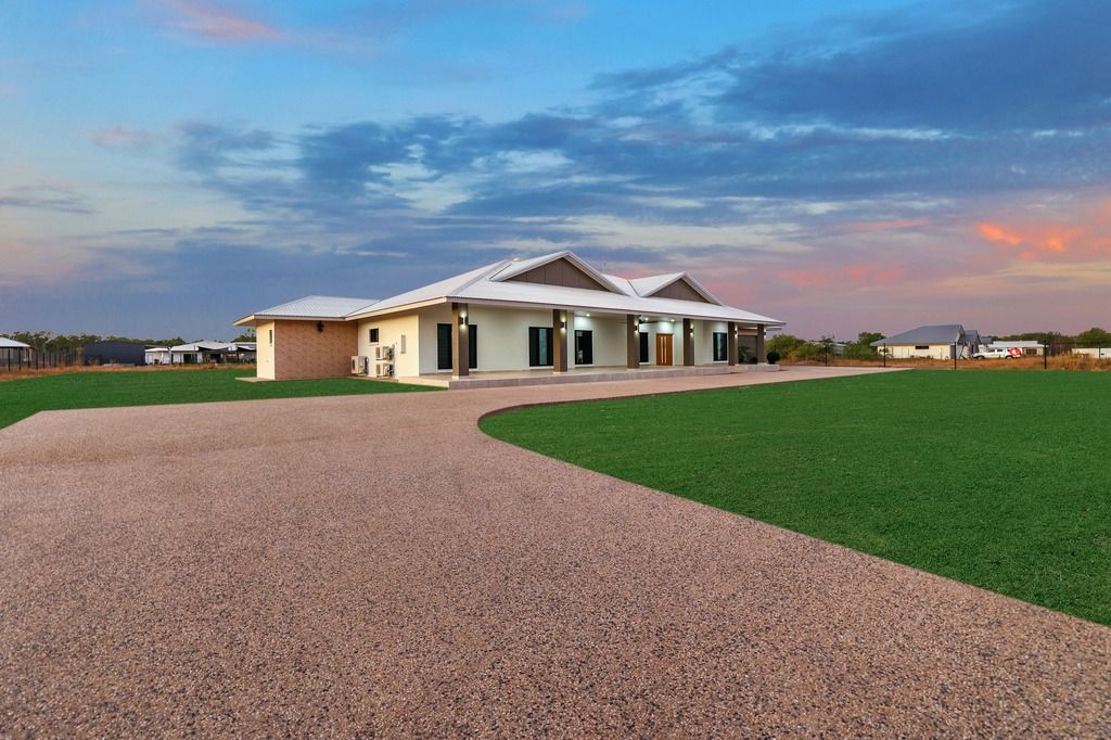 An empty living room with a ceiling fan and a stone wall.