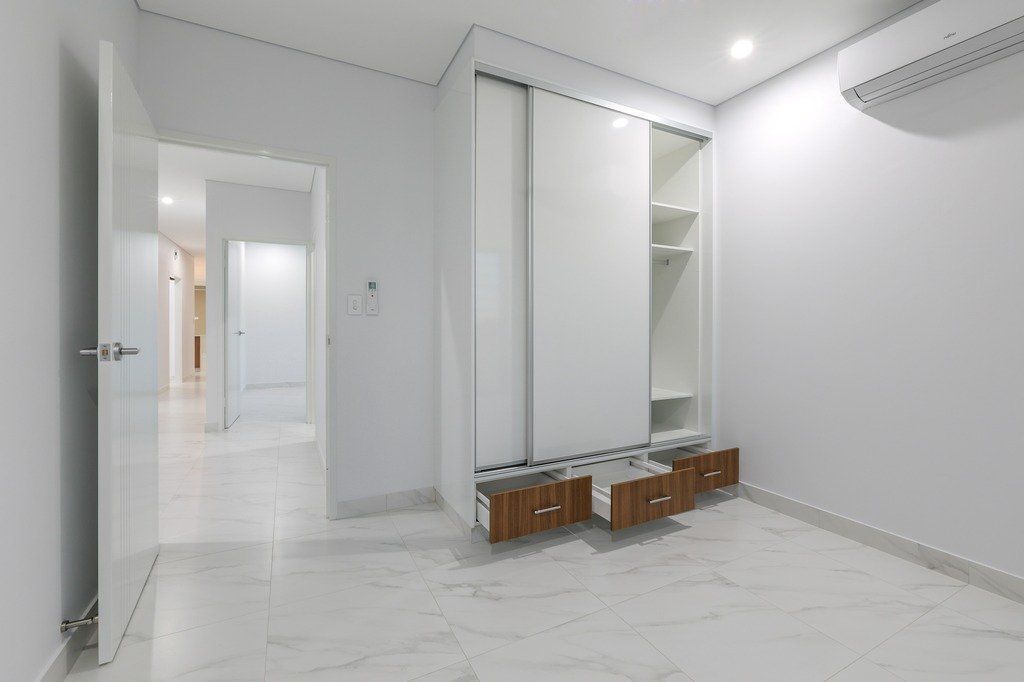 An empty room with a sliding glass door and a marble floor.