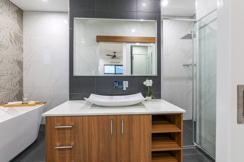 A bathroom with a sink , mirror and bathtub.