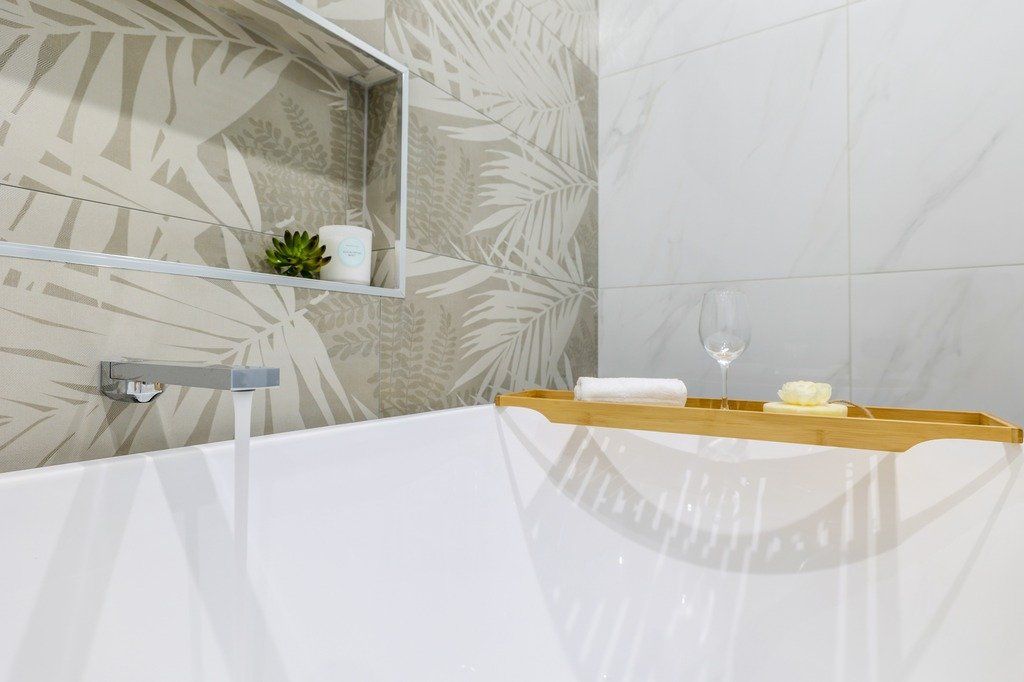 A bathtub with a wooden tray on top of it in a bathroom.