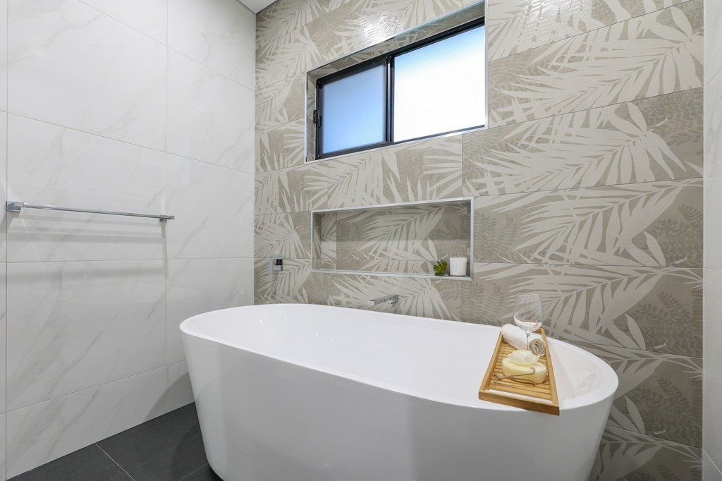 A bathroom with a bathtub and a window.