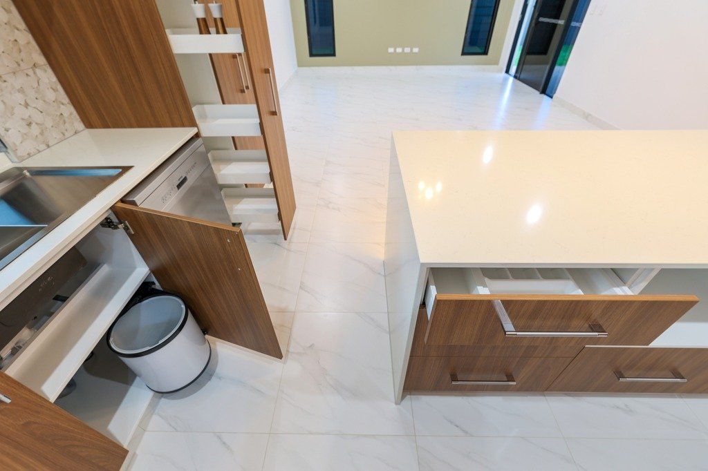 A kitchen with wooden cabinets and white counter tops