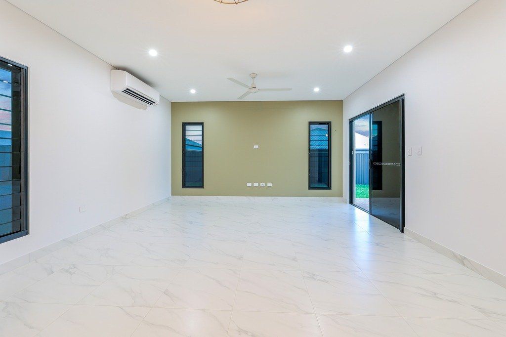 A large empty room with sliding glass doors and a ceiling fan.