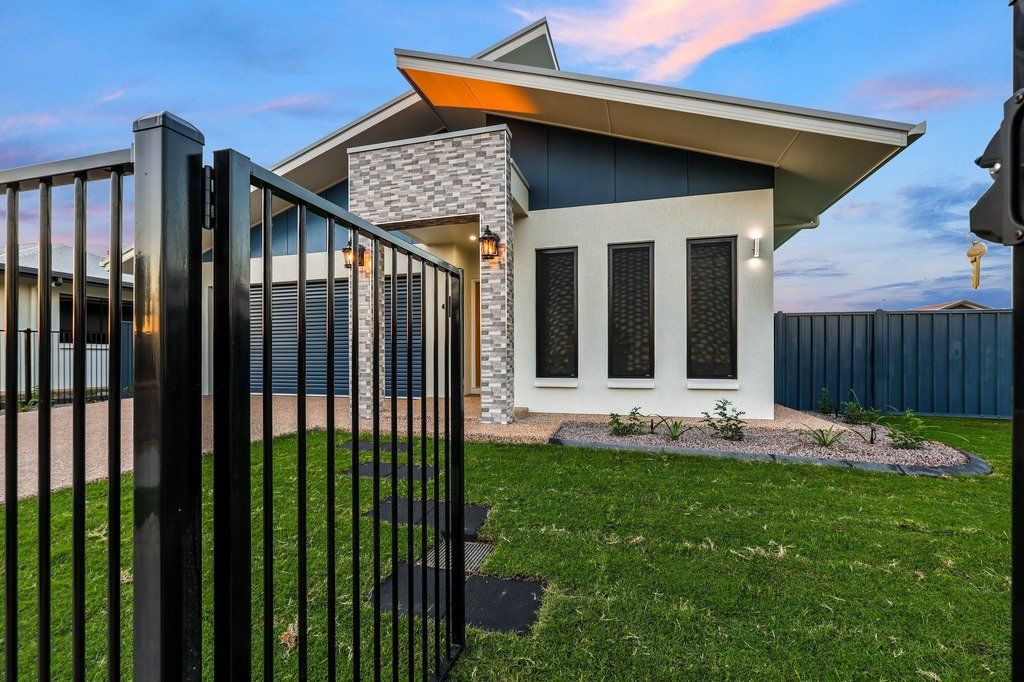 A modern house with a black fence in front of it.