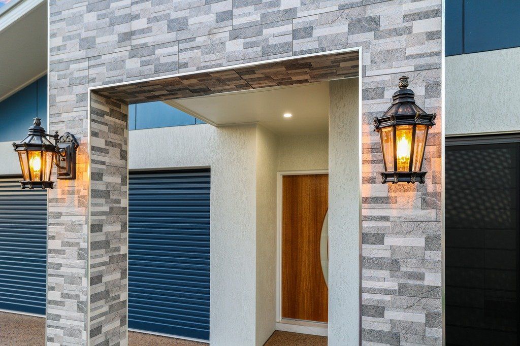 The front door of a house with two lanterns on the wall.