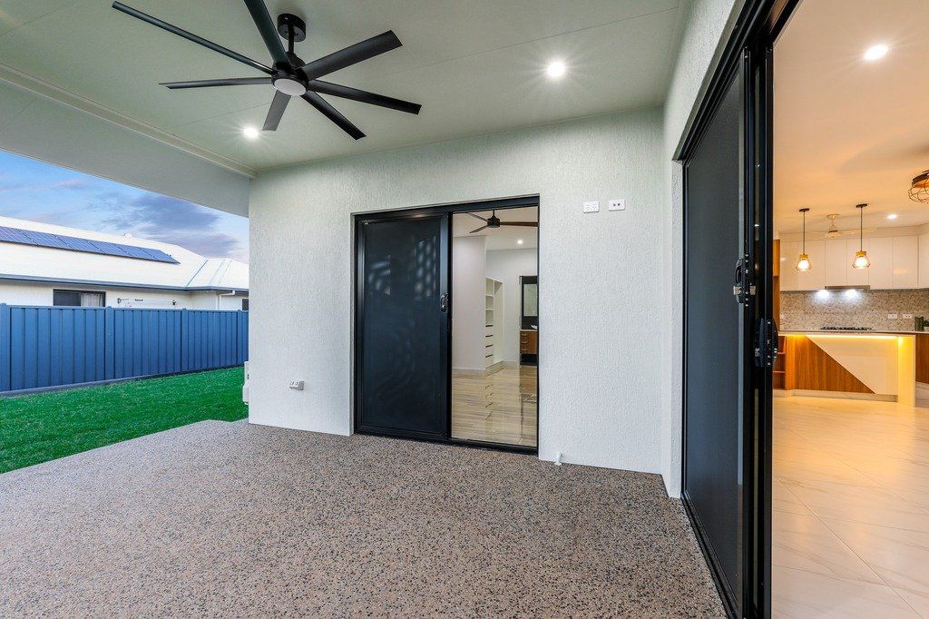 There is a ceiling fan in the backyard of a house.