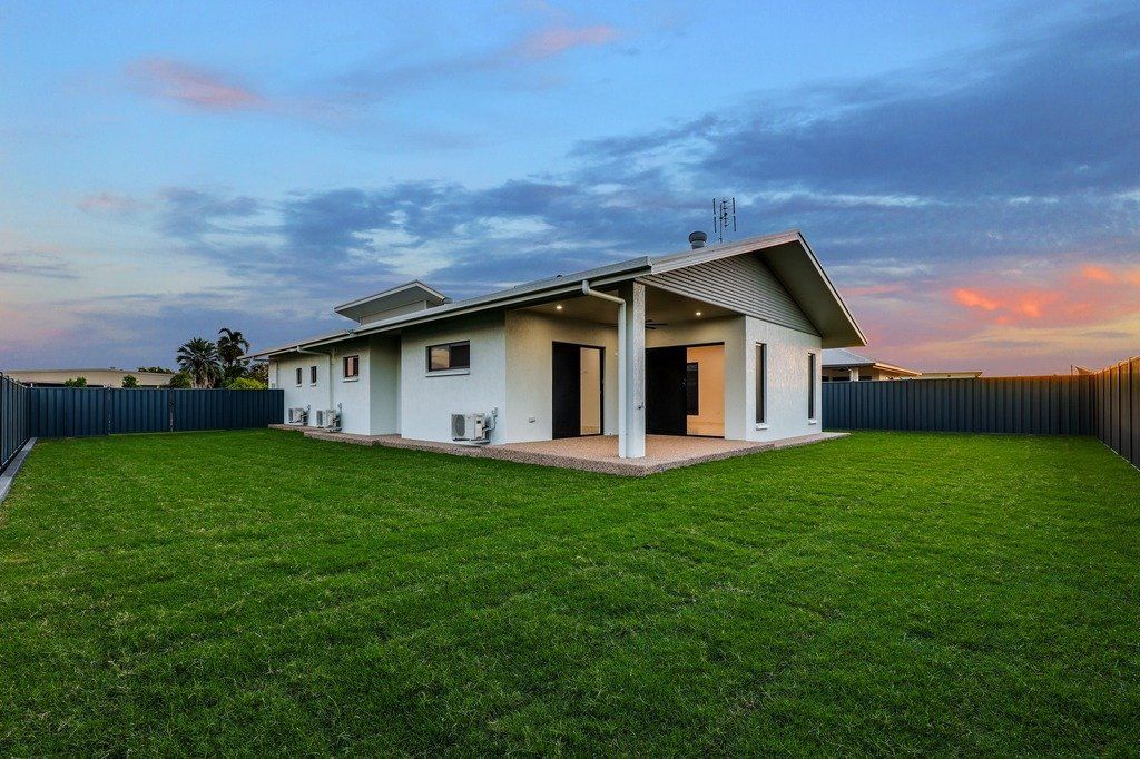 A white house with a large lawn in front of it.