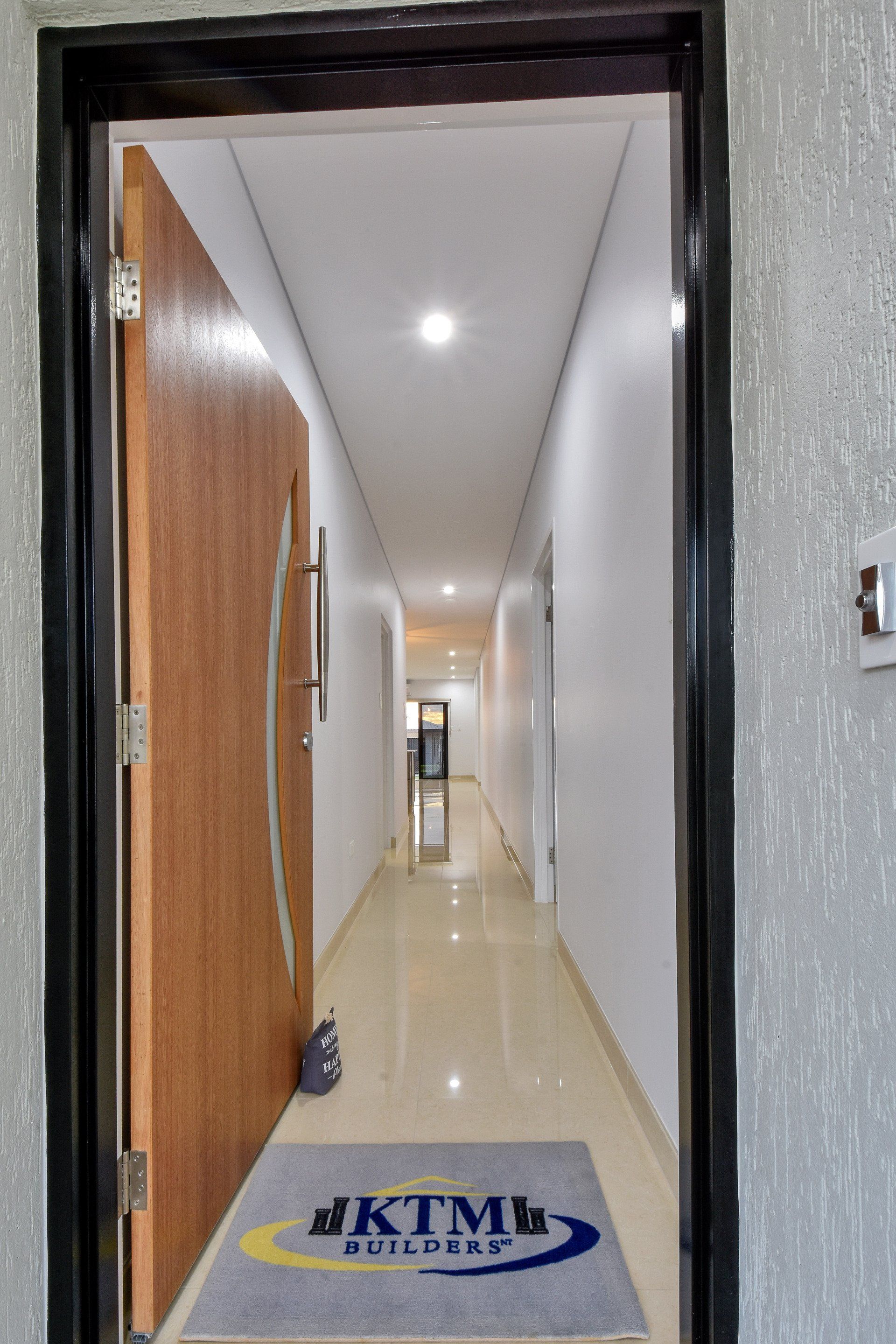 A hallway with a door and a mat that says ktm on it.
