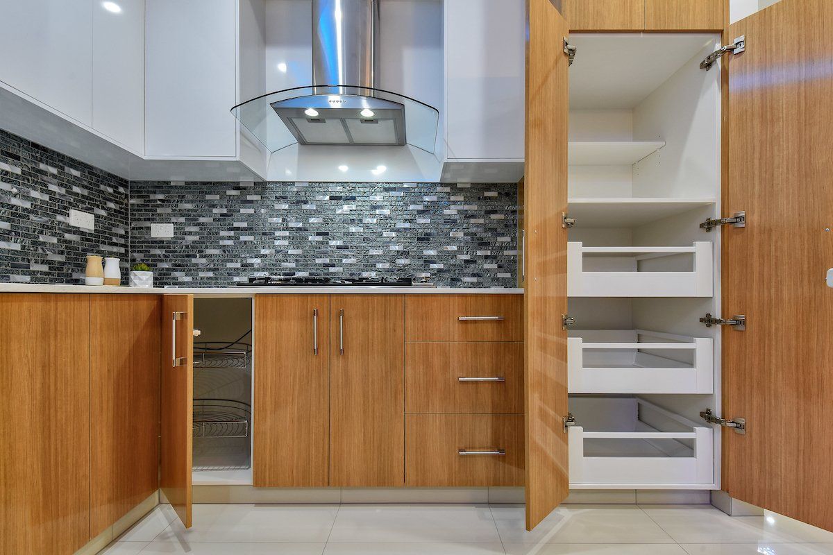 A kitchen with wooden cabinets and drawers and a stove top oven.