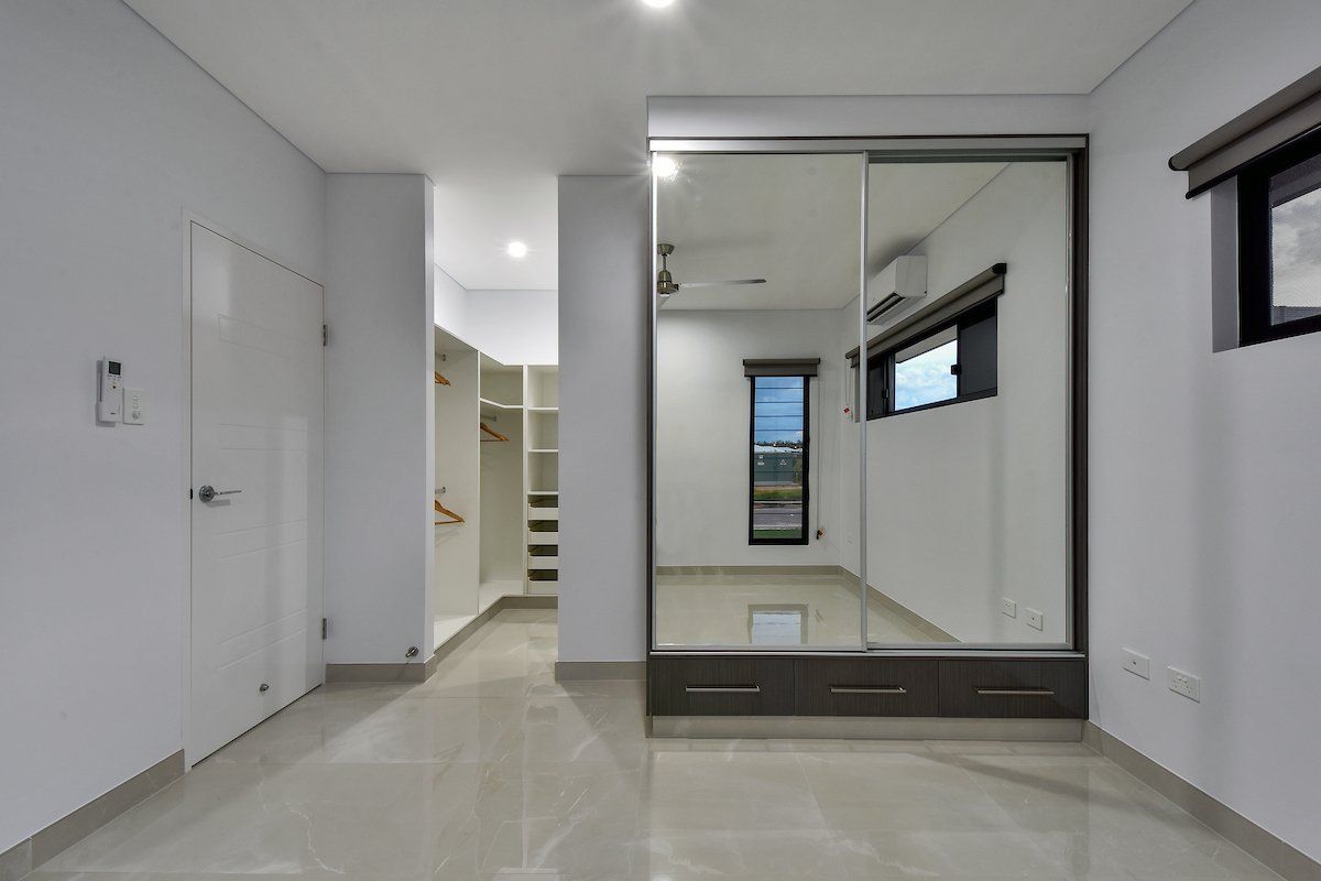 An empty room with a sliding glass door and a window.