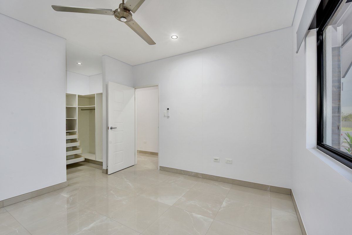 An empty bedroom with a ceiling fan and a walk in closet.