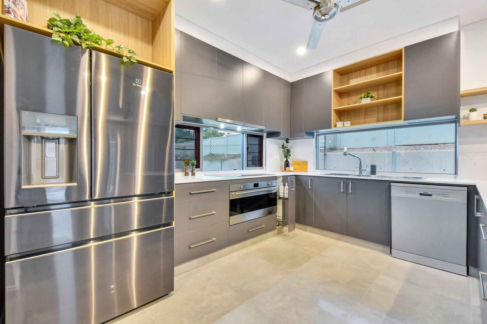 A kitchen with stainless steel appliances and a ceiling fan.