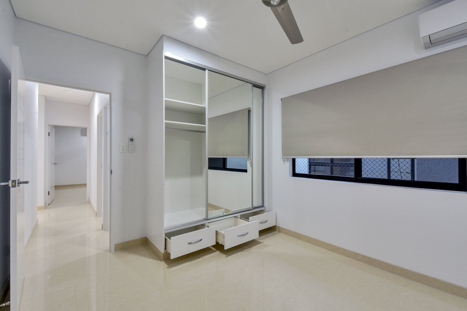 There is a ceiling fan in the room and a large mirror on the wall.