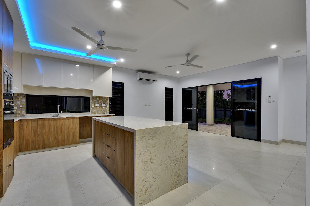 A kitchen with a large island and a ceiling fan