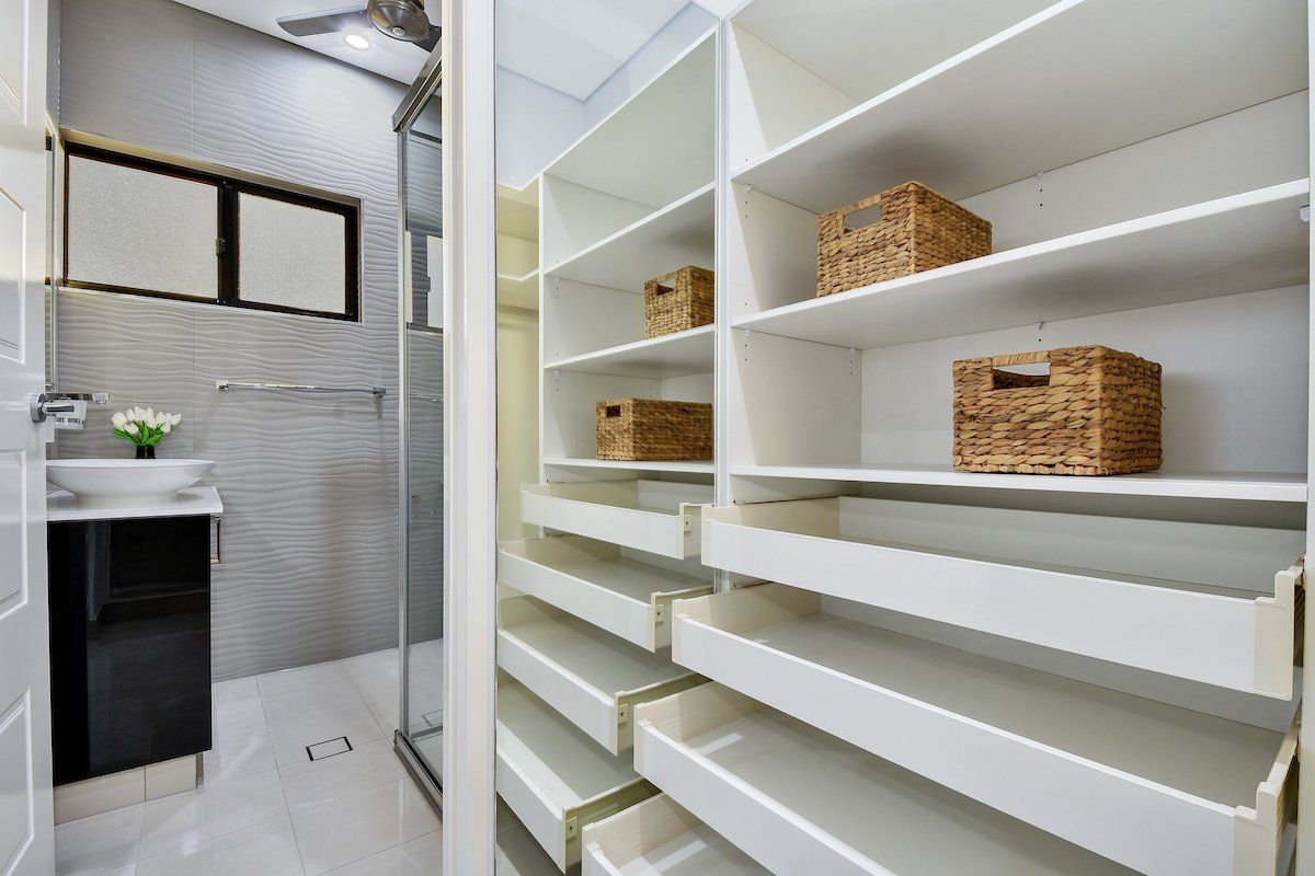 A walk in closet with drawers and shelves in a bathroom.