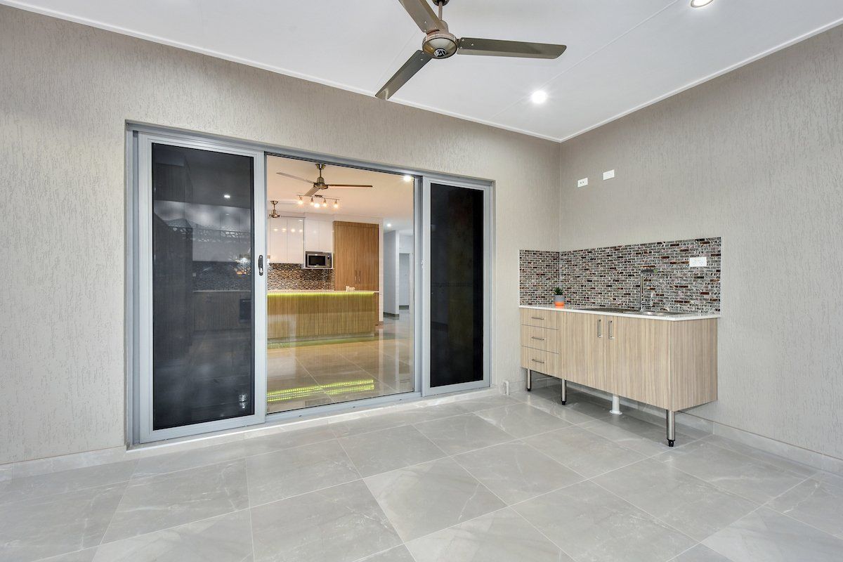 A room with a sliding glass door and a ceiling fan.