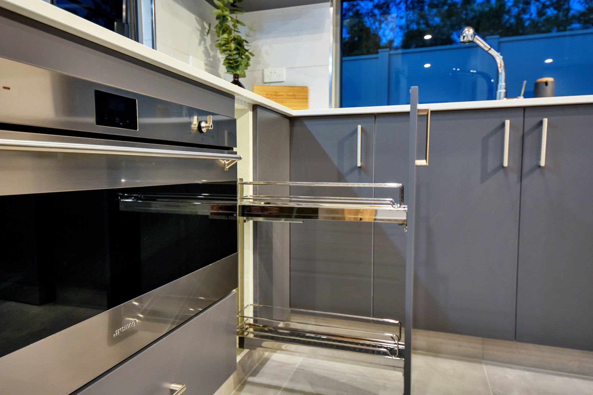 A kitchen with stainless steel appliances and gray cabinets