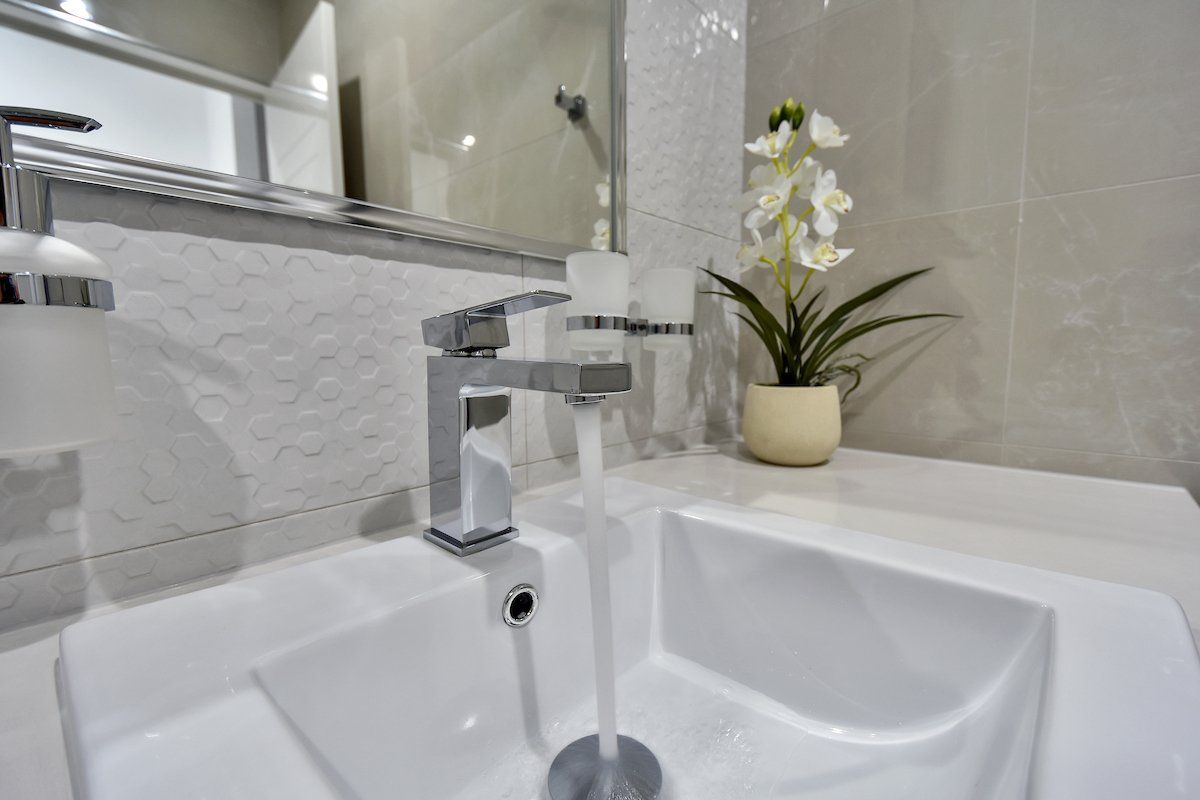 A bathroom sink with water running from the faucet.