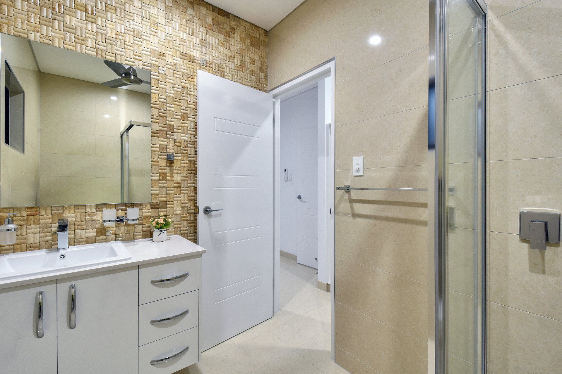 A bathroom with two sinks , a mirror and a walk in shower.