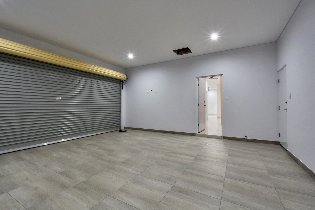 An empty room with a garage door and a doorway.