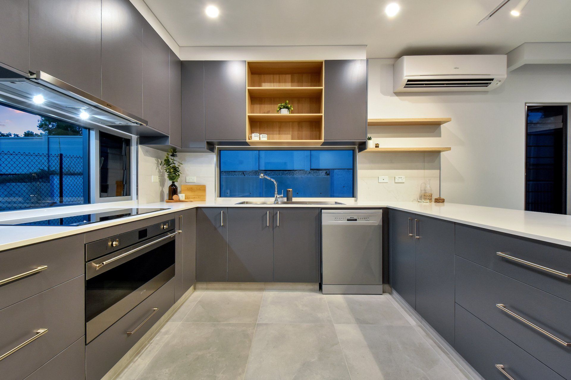 A kitchen with stainless steel appliances and gray cabinets