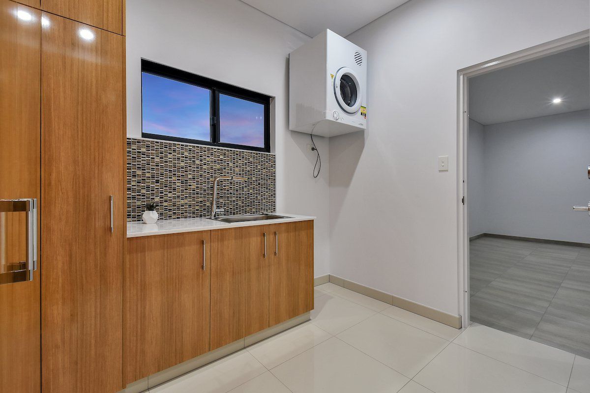 A laundry room with a washer and dryer and a sink.