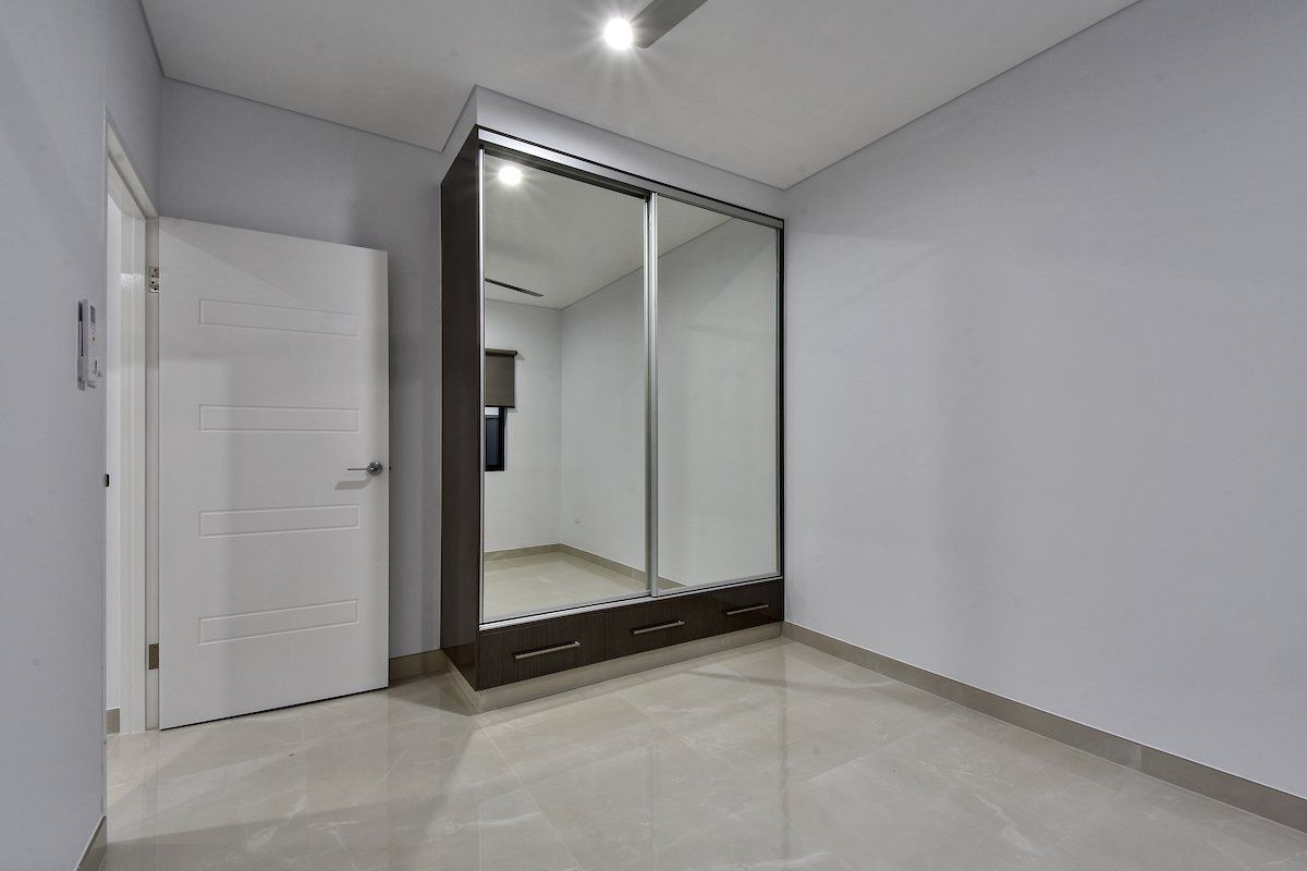 An empty bedroom with a large mirrored wardrobe