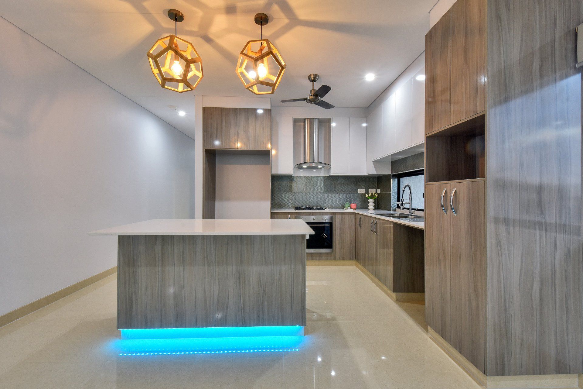 A kitchen with a large island and a ceiling fan.