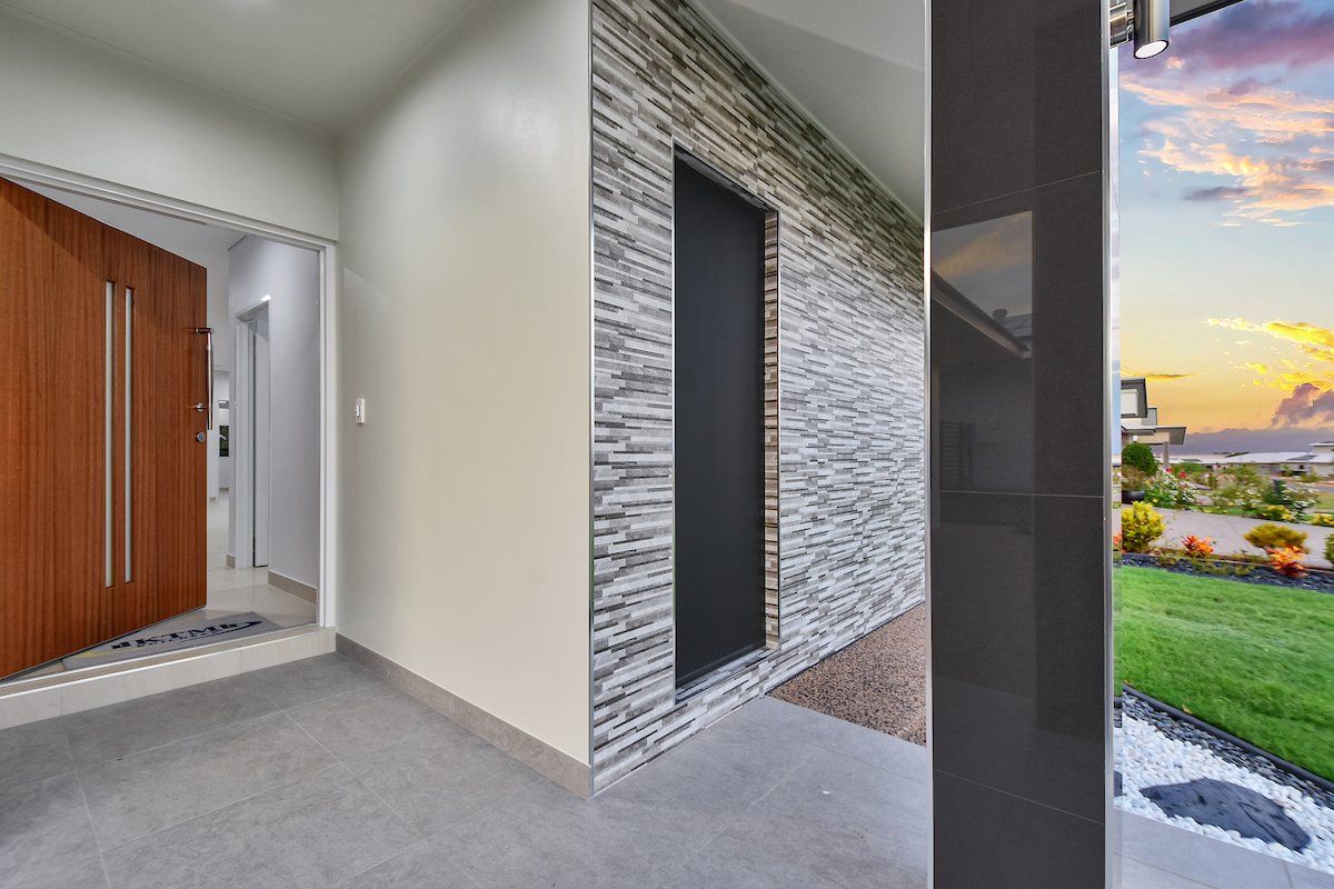 A hallway in a house with a brick wall and a black door.
