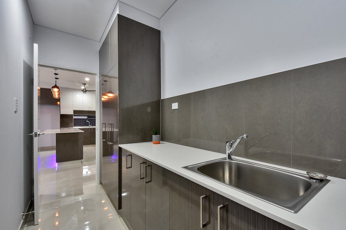 A kitchen with a sink and cabinets and a hallway
