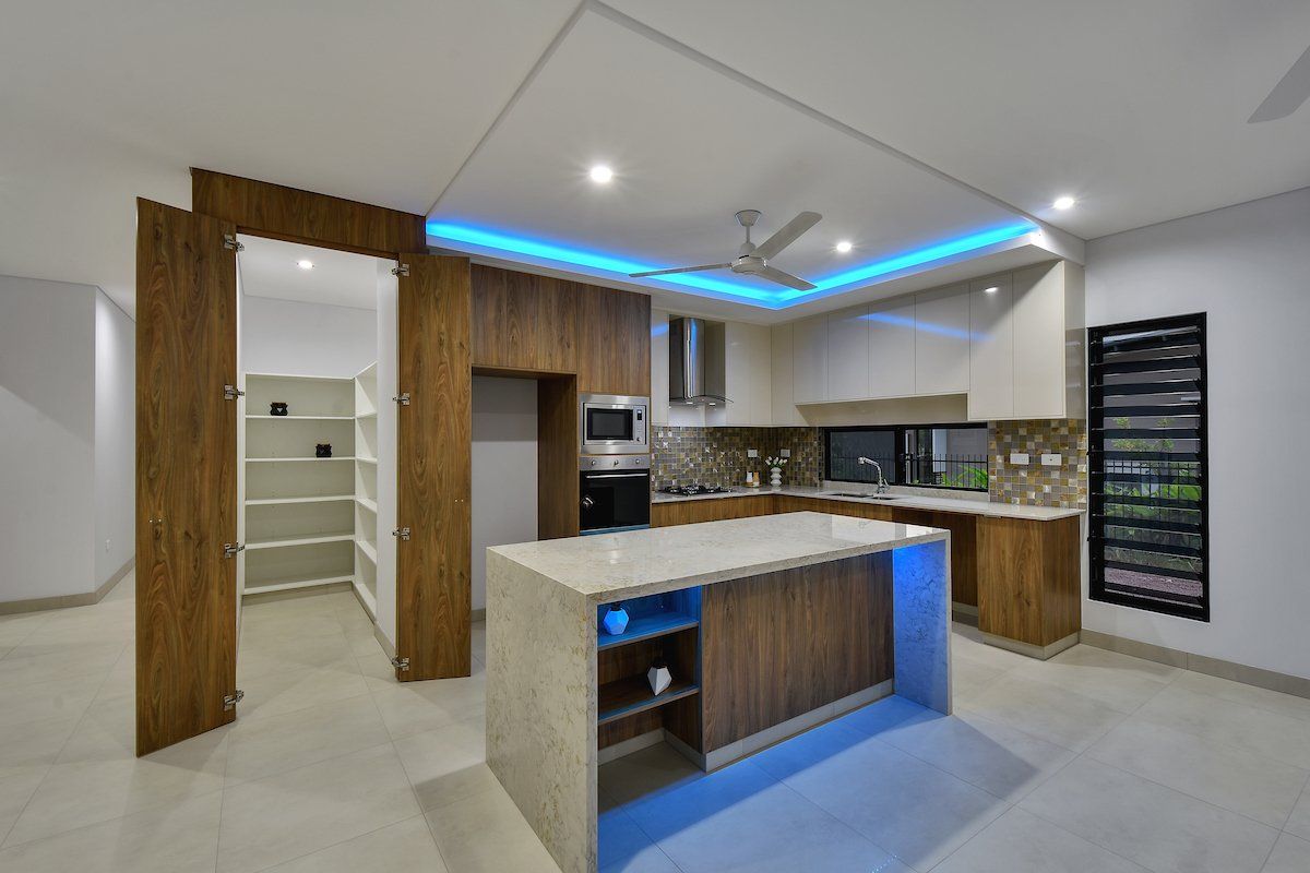 A kitchen with a large island and a ceiling fan.