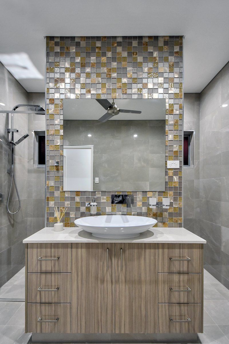 A bathroom with a sink , mirror and ceiling fan.