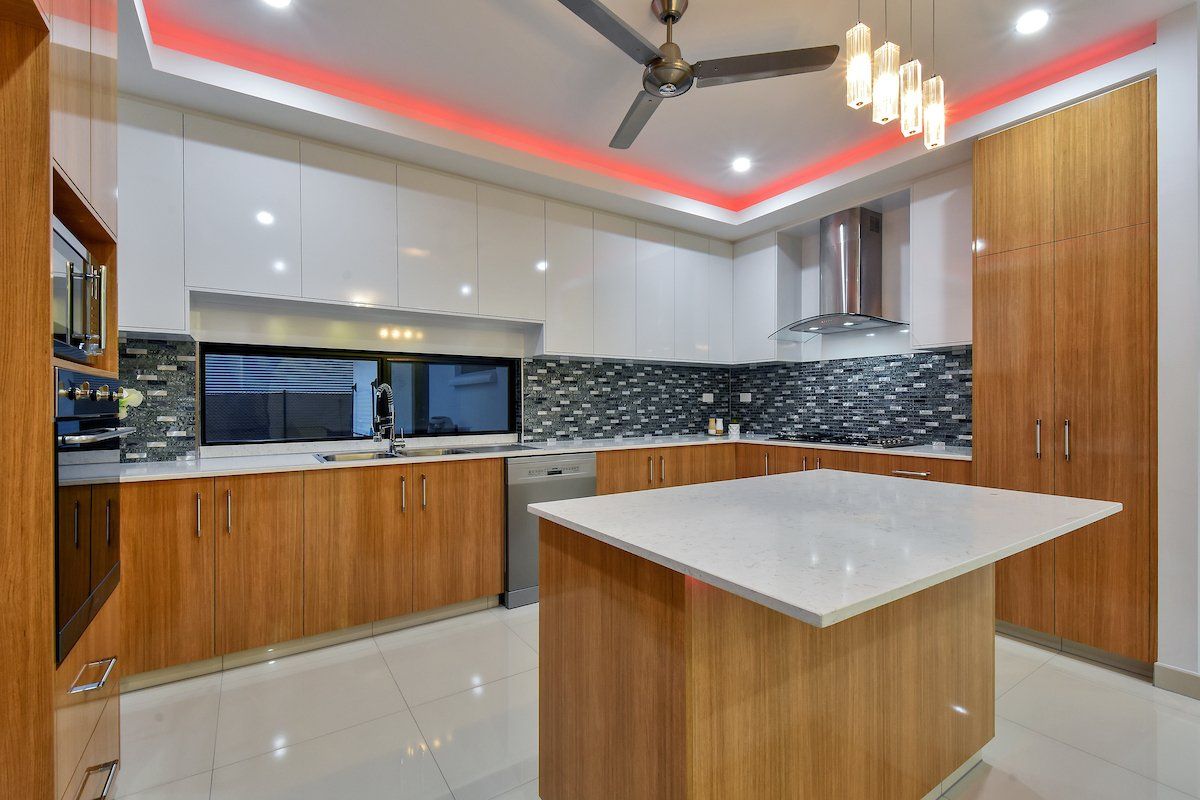 A kitchen with a large island and a ceiling fan